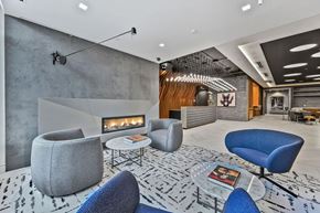 Washington apartment for rent - Mount Vernon Triangle, Washington, DC, High-Rise Apartments Near Georgetown University Law Center - Claret - Lobby Area With Reception Desk, Light-Colored Tiles, Pendant Lighting, Wavy Feature Wall.