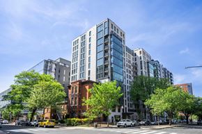 Washington apartment for rent - Mount Vernon Triangle, Washington, DC, Luxury Apartments Near Georgetown University Law Center - Claret - Building Exterior Of A Multi-Story Building With Glass Windows, Balconies, And Lush Trees.