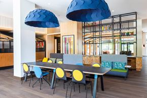 Washington apartment for rent - a dining room with blue chairs and a long table with chairs at The Chase at Bryant Street, Washington, DC