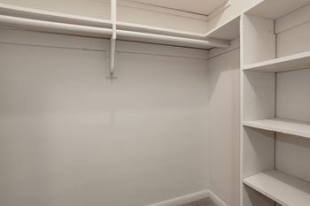 A white closet with a shelf and a hanging rod