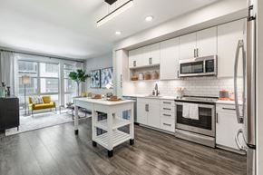 Washington apartment for rent - a kitchen with white cabinets and stainless steel appliances at Coda at Bryant Street, Washington District of Columbia