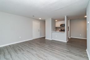 Lorton apartment for rent - the living room and kitchen of an apartment with wood flooring at The Fields at Lorton Station, Virginia