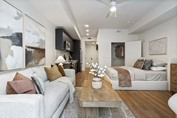 Jacksonville apartment for rent - A modern living room with a grey couch, a wooden coffee table, and a large abstract painting on the wall.