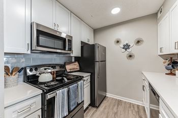 A kitchen with white cabinetry and stainless steel appliances