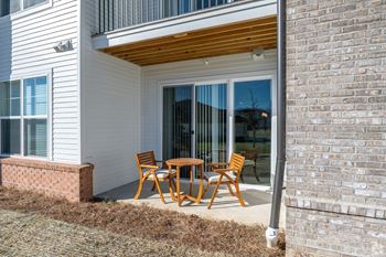 A patio with a table and chairs outside of a house