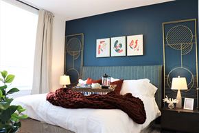 Ashburn apartment for rent - a bedroom with a blue wall and a white bed with a white comforter at Vyne One Loudoun, Ashburn, VA, 20147