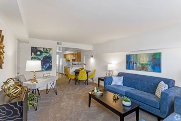 Chevy Chase apartment for rent - a living room with blue couches and yellow chairs and a kitchen with a table