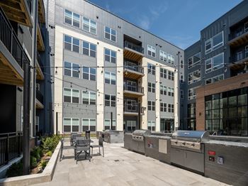 A modern building with a patio and outdoor furniture.