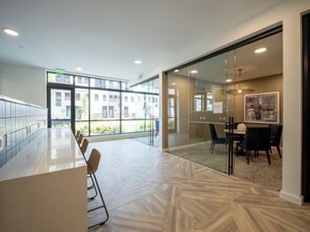 A modern office space with a reception desk and a dining area.