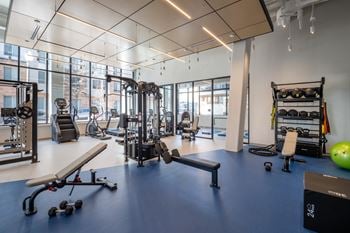 A gym with a variety of equipment including weights and cardio machines