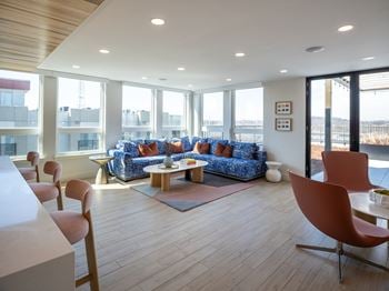 A living room with a blue couch and a wooden floor