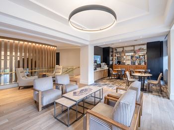 A lounge area with chairs and tables and a bar