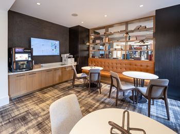 A lounge area with tables and chairs and a television