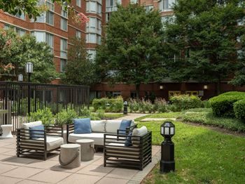 A patio with a couch and chairs in a courtyard