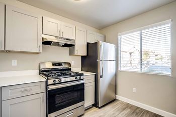 A kitchen with a stove, oven, and refrigerator.