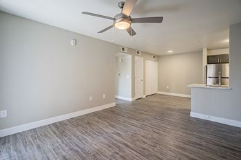 A room with a ceiling fan and wooden flooring.