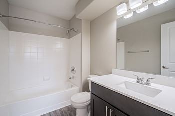 A white bathroom with a toilet, sink, and bathtub.