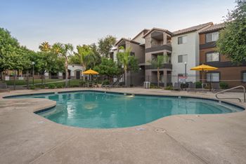A swimming pool in front of apartment buildings.