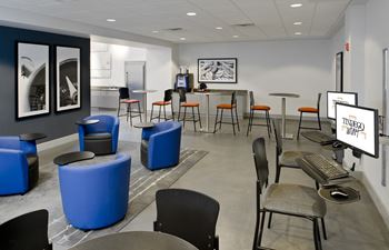 A room with tables and chairs and a computer in a room