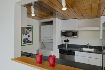 A kitchen with white cabinets and a sink and a microwave