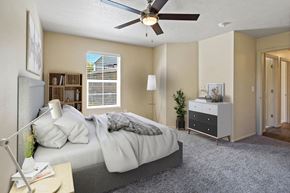 Bluffdale apartment for rent - A bedroom with a bed, nightstand, and a ceiling fan. at Bluffs Apartments, Bluffdale