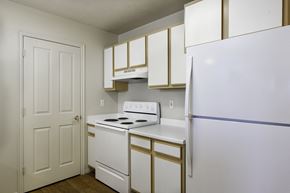 Bluffdale apartment for rent - A white and gold kitchen with a white fridge. at Bluffs Apartments, Bluffdale, Utah
