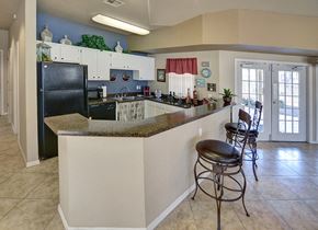 Casa Grande apartment for rent - A kitchen with a black refrigerator and white cabinets.at Cottonwood Crossing, Casa Grande, 85122  