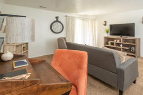 Ogden apartment for rent - A living room with a grey couch, a wooden coffee table, and a television.at Country Woods, Ogden, UT 84401