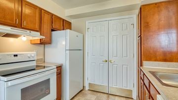 Frederick apartment for rent - a kitchen with white appliances and wooden cabinets