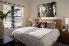 Tampa apartment for rent - A bedroom with a large bed and a painting on the wall.