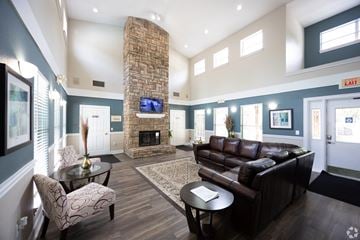 Duluth apartment for rent - a living room with a leather couch and a stone fireplace