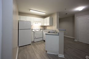 Duluth apartment for rent - an empty kitchen with white appliances and white cabinets at Magnolia Pointe Apartments in Duluth, GA