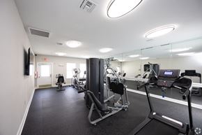 Duluth apartment for rent - a gym with exercise equipment and mirrors in a building at Magnolia Pointe Apartments in Duluth, GA