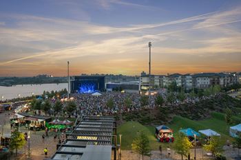 A crowd of people in front of a stage at dusk