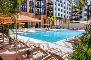 A pool surrounded by lounge chairs and umbrellas