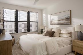 Tampa apartment for rent - A bedroom with a large bed and a painting on the wall at The Stevedore Apartments in Tampa, FL 33605