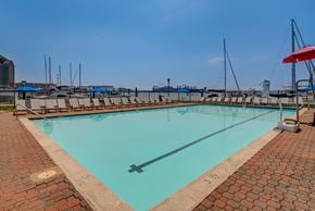 Baltimore apartment for rent - A rectangular pool with a brick border and a diving board.