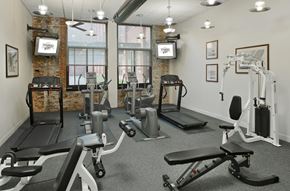 Baltimore apartment for rent - a gym with weights and exercise equipment in a room with windows at Tindeco Wharf, Baltimore, MD