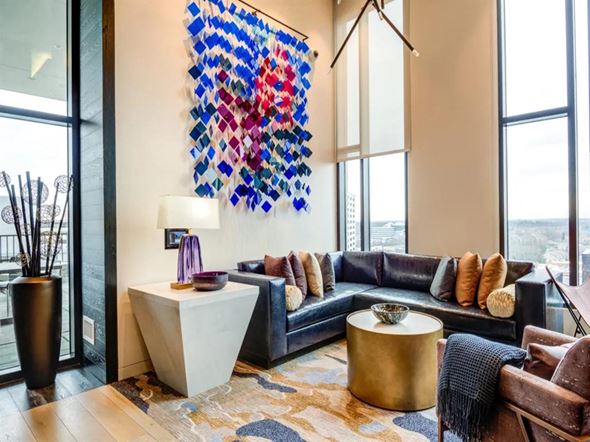 Tysons apartment for rent - a living room with a black couch and a large colorful painting on the wall at The Boro, Tysons, VA