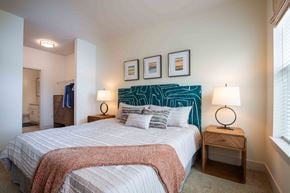 Bowie apartment for rent - a bedroom with a bed and pictures on the wall at Woodmore Grand, Bowie