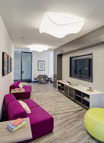 A living room with a purple couch and a television