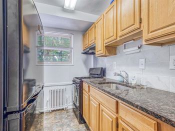 A kitchen with wooden cabinets and granite countertops