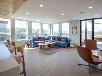 A living room with a blue sofa and wooden floors.