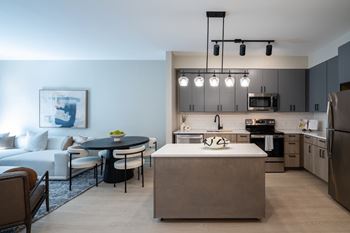 A modern kitchen with a dining table and chairs.
