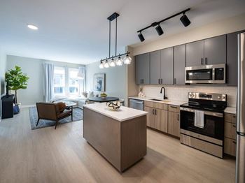 A modern kitchen with a wooden island and stainless steel appliances.