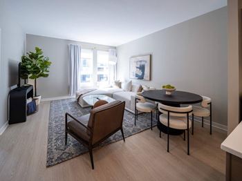 A living room with a black table and white chairs.