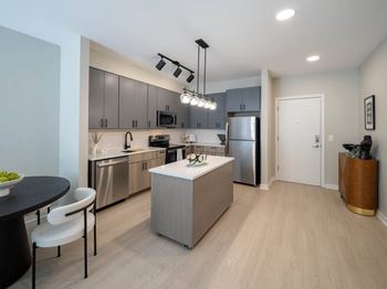 A modern kitchen with stainless steel appliances and a wooden island.