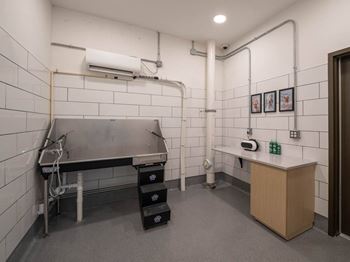 A kitchen with a stainless steel table and a white tile wall.