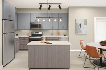 A modern kitchen with a grey island and brown chairs.
