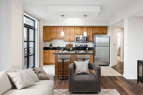 Washington apartment for rent - A modern kitchen with wooden cabinets and a refrigerator. at Loree Grand at Union Place, Washington, DC, 20002